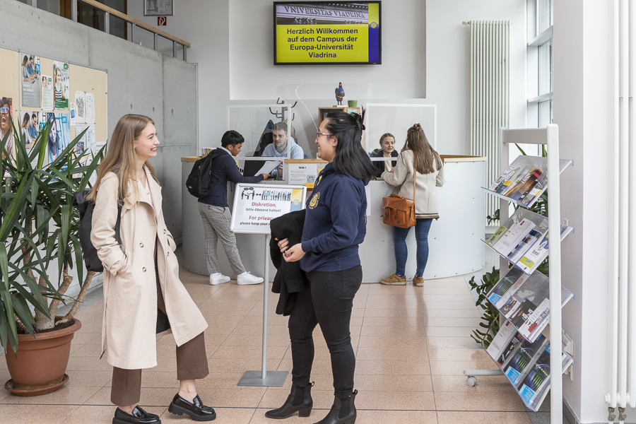 Studierende stehen vor dem Infopoint im Viadrina Auditorium Maximum